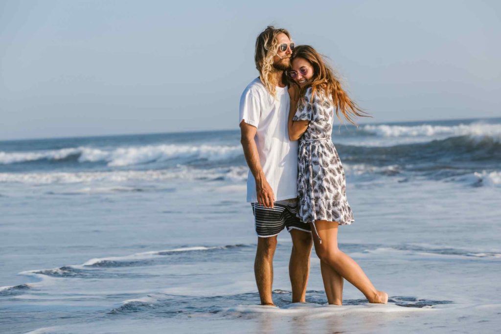 Couple cuddling on ocean beach in Bali, Indonesia